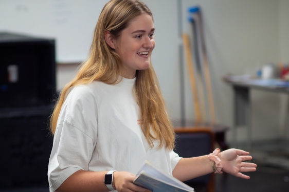 photo of woman holding notebook, arms extended