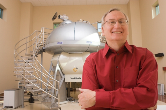 Photo of man standing in front of NMR machine